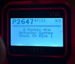Pantalla del escáner OBD2 V100 mostrando el código de diagnóstico P2647 y la descripción de la falla.
